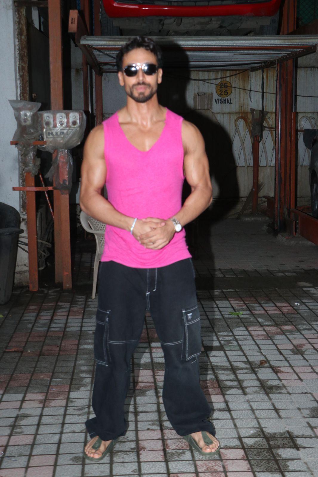 Tiger Shroff was seen outside a gym today in the city. He wore a pink vest with black track pants. He completed the look with a black cap and sunglasses.